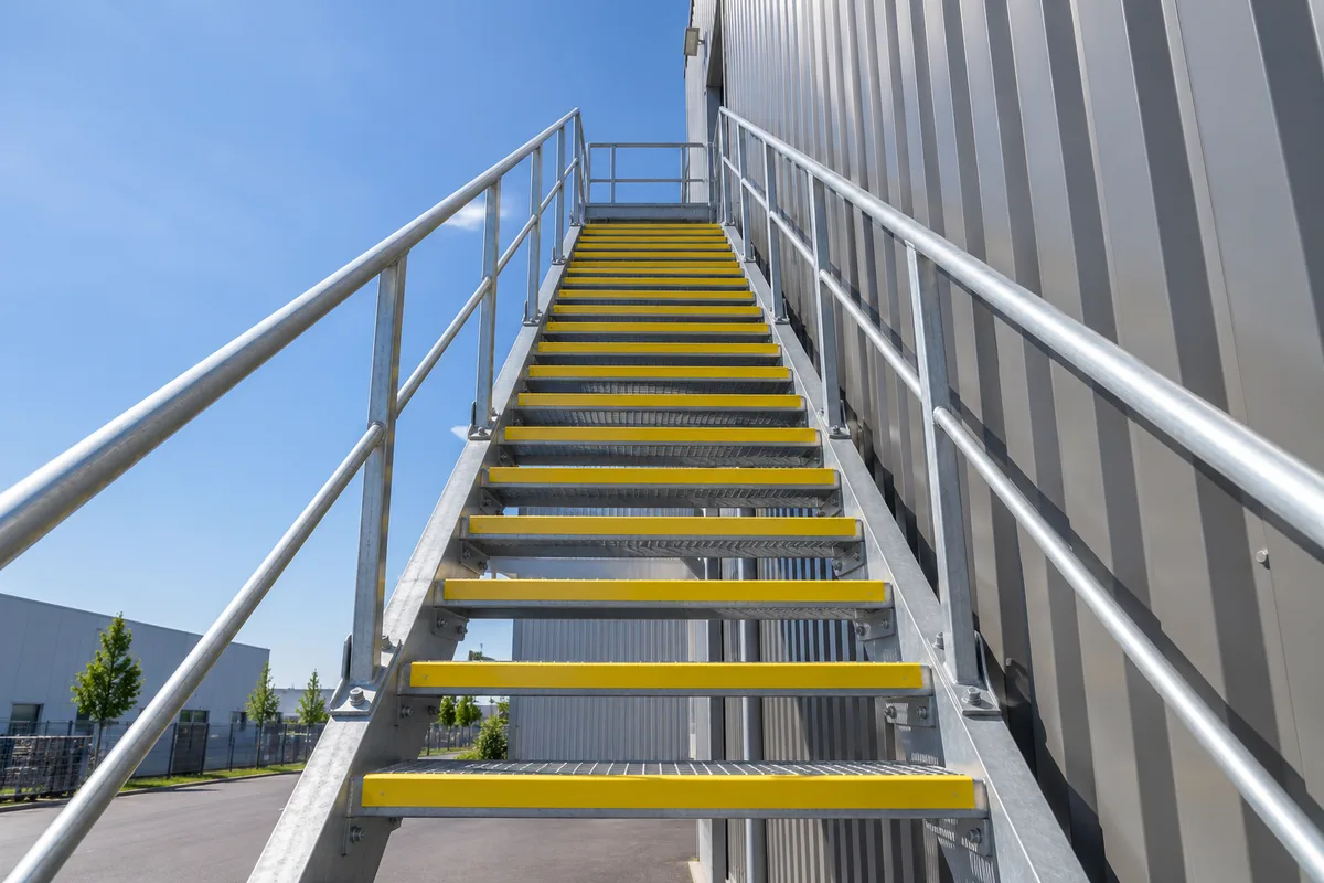 Escalier extérieur de secours en acier galvanisé contre la façade d&rsquo;un entrepôt